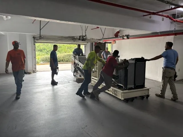 Wavelength Electrical Contracting crew moving a commercial generator through a parking garage