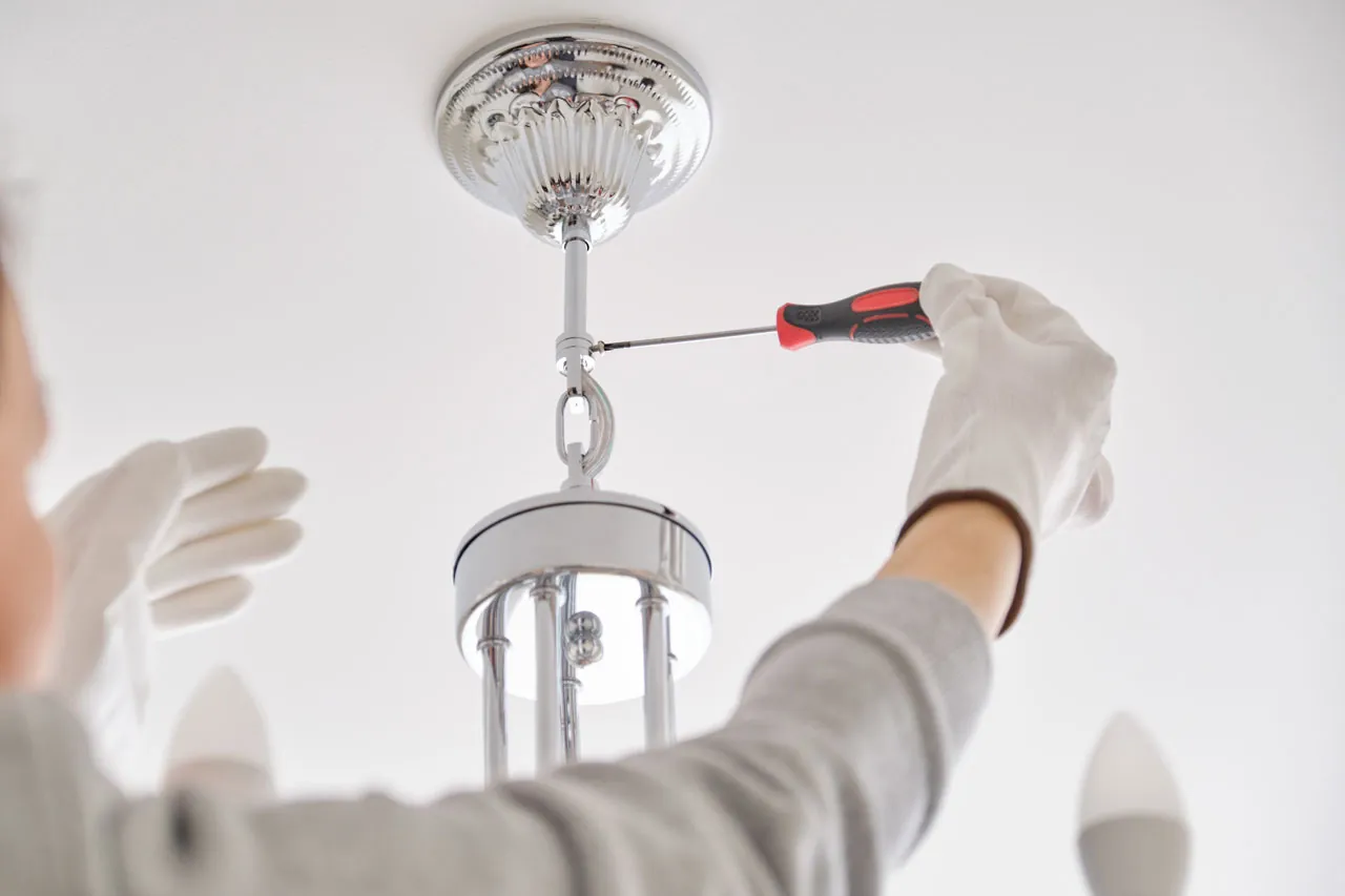 Electrician installing a ceiling light fixture