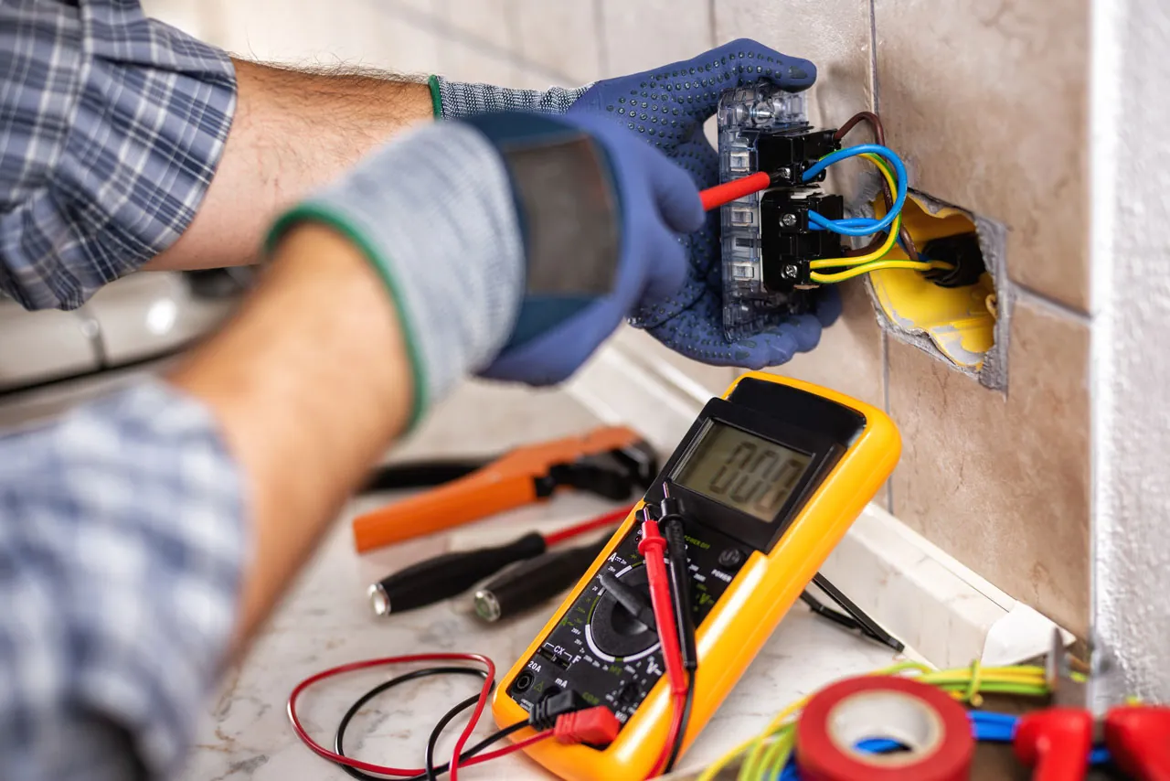 Electrician testing an outlet with a multimeter