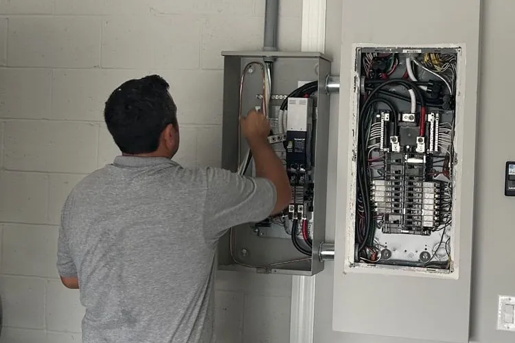 Electrician in Melbourne, FL wiring a circuit breaker panel