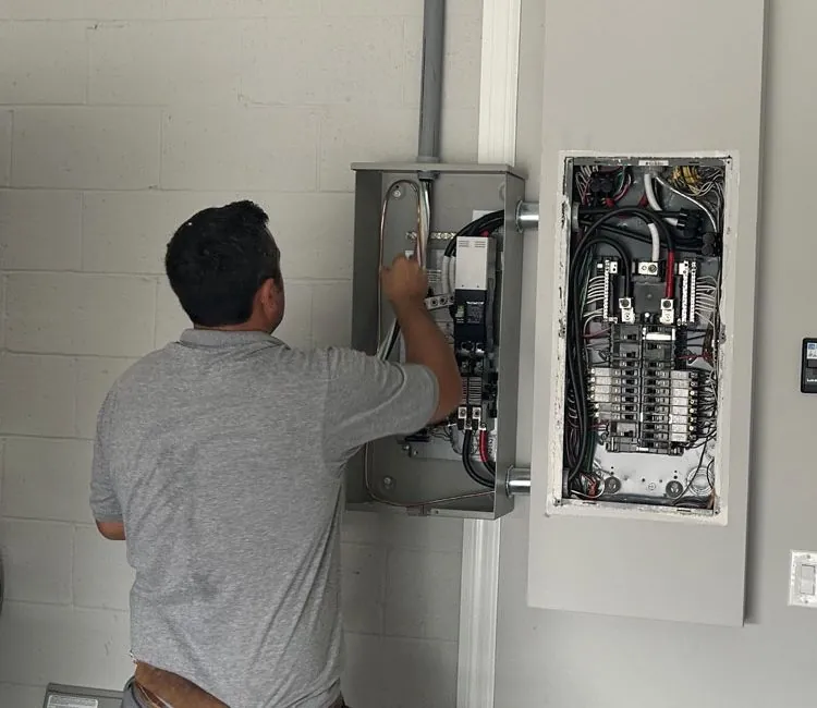 Electrician in Melbourne, FL wiring a circuit breaker panel