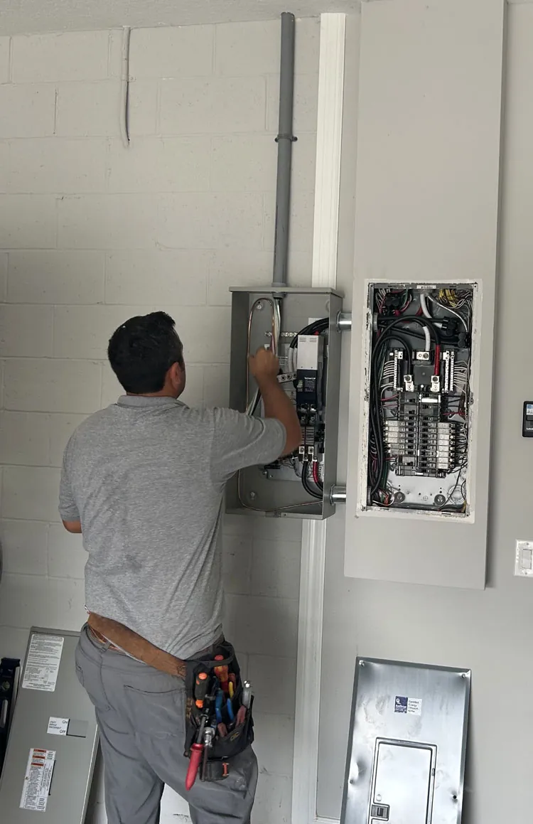 Wavelength Electric technician wiring a generator transfer switch and panel at a Merritt Island, FL home
