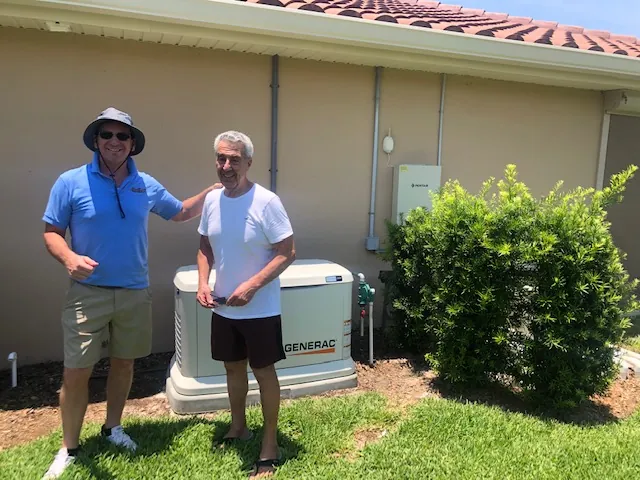 Homeowner with a Wavelength electrician beside a newly installed Generac generator on a concrete pad