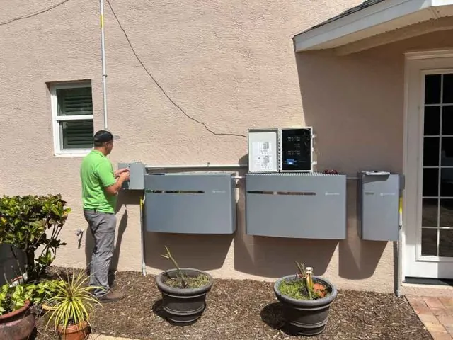 Electrician in Melbourne, FL wiring generator transfer switch panels on a home exterior