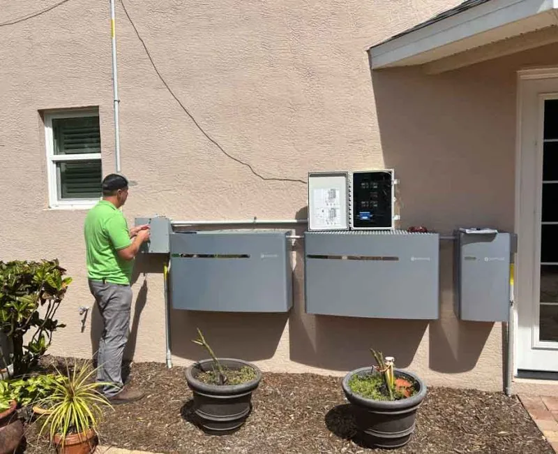 Electrician in Melbourne, FL wiring generator transfer switch panels on a home exterior
