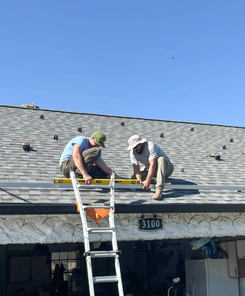 Wavelength Electric crew installing rooftop solar mounting hardware